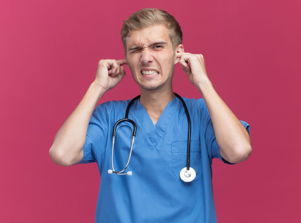 Person experiencing ear pain after blowing their nose due to Eustachian tube dysfunction, sinus congestion, or a middle ear infection.