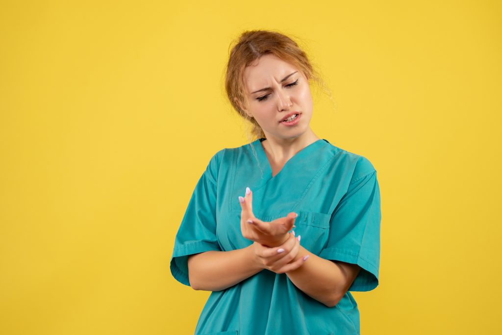 Person holding their middle finger due to joint pain caused by arthritis, tendonitis, injury, or repetitive strain.