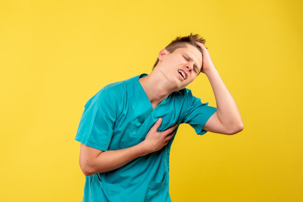 Person holding their chest and upper back while experiencing pain when breathing, illustrating possible causes such as muscle strain, pleurisy, pneumonia, or rib inflammation.
