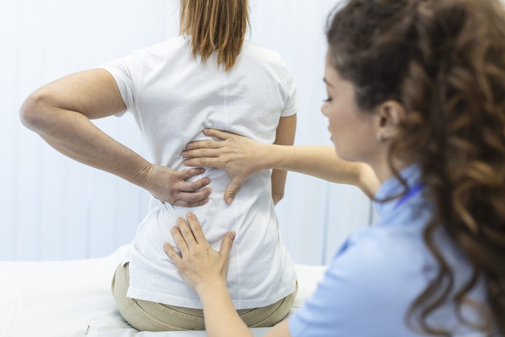 Physiotherapist treating back pain patient