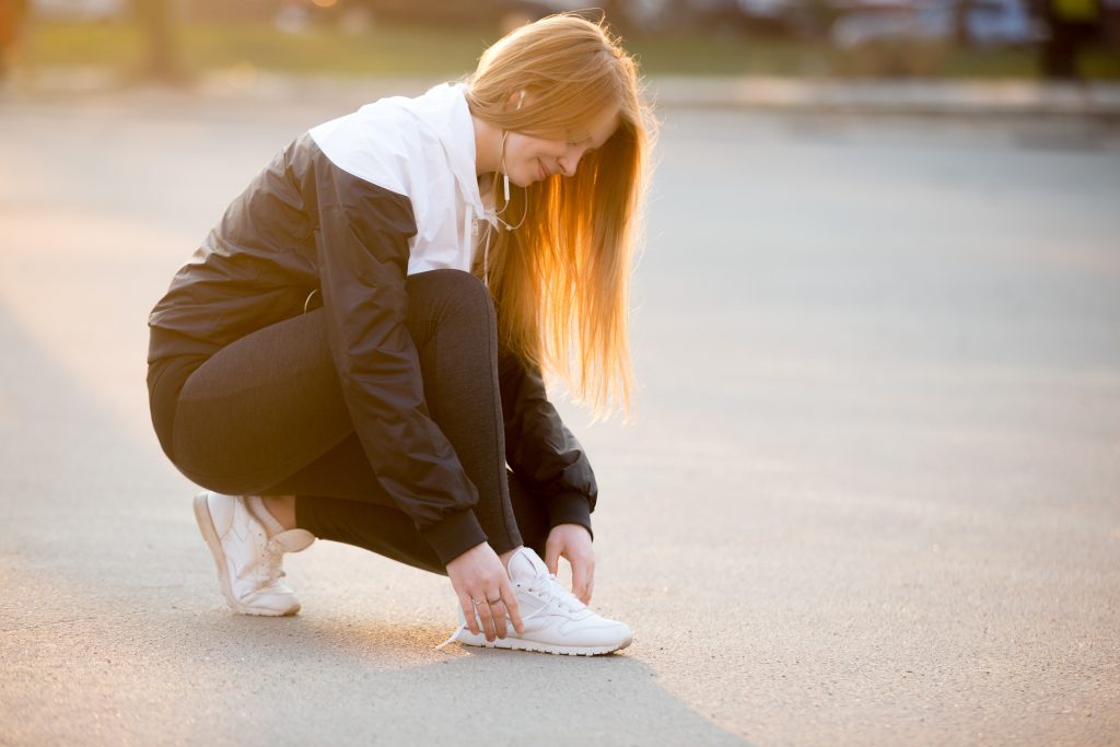 Girl holding her painful foot after walking